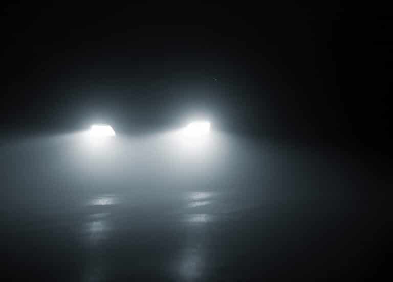En bils strålkastarljus i mörker