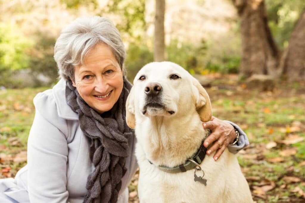 Äldre kvinna som poserar med en av de bra hundraser för pensionärer på vår lista